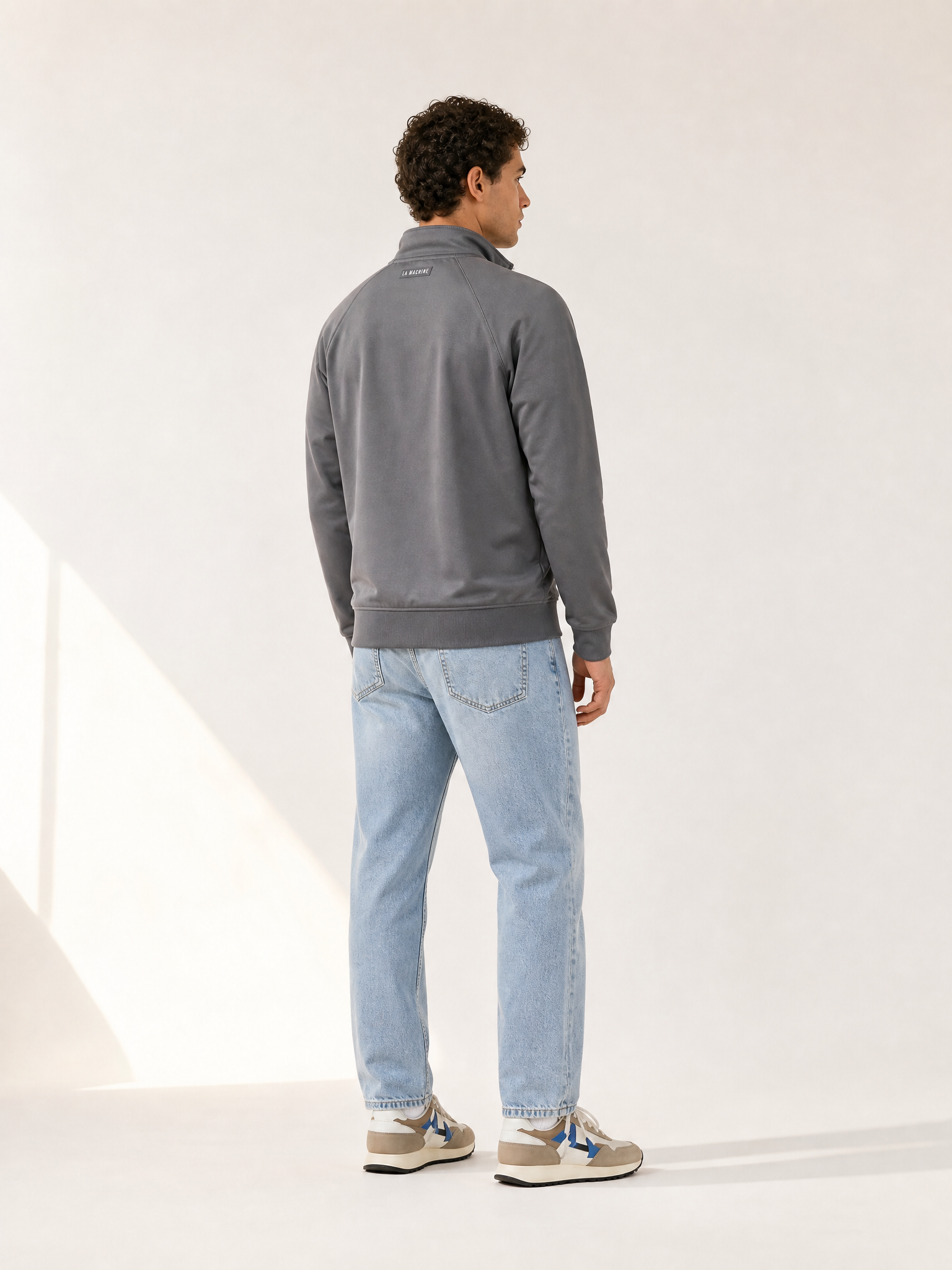 A model wearing the Coffee Ride Winners Club - Track Jacket - Steel Grey by La Machine Cycle Club.