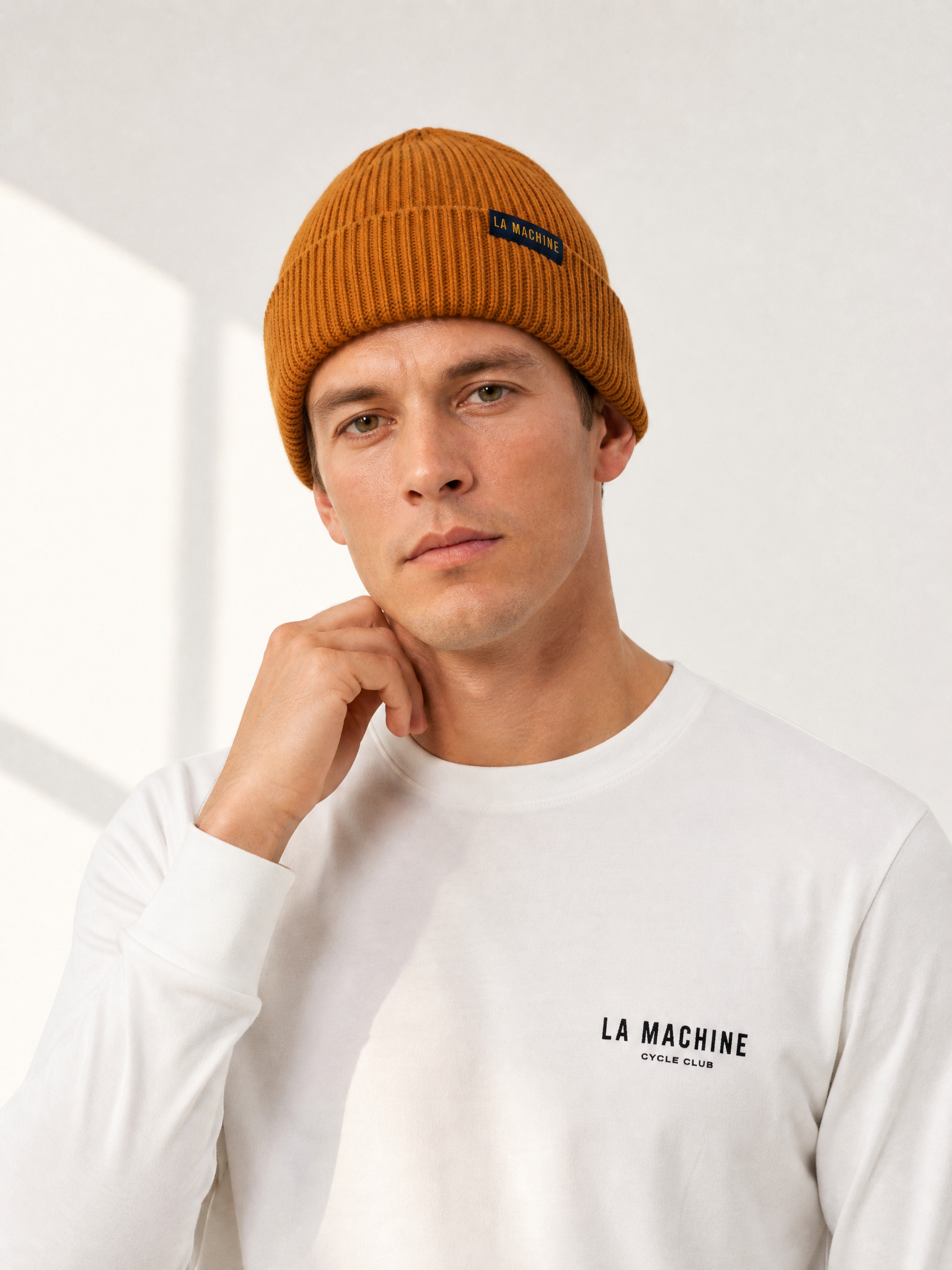 A model wearing the La Machine - Beanie - Burnt Orange by La Machine Cycle Club.