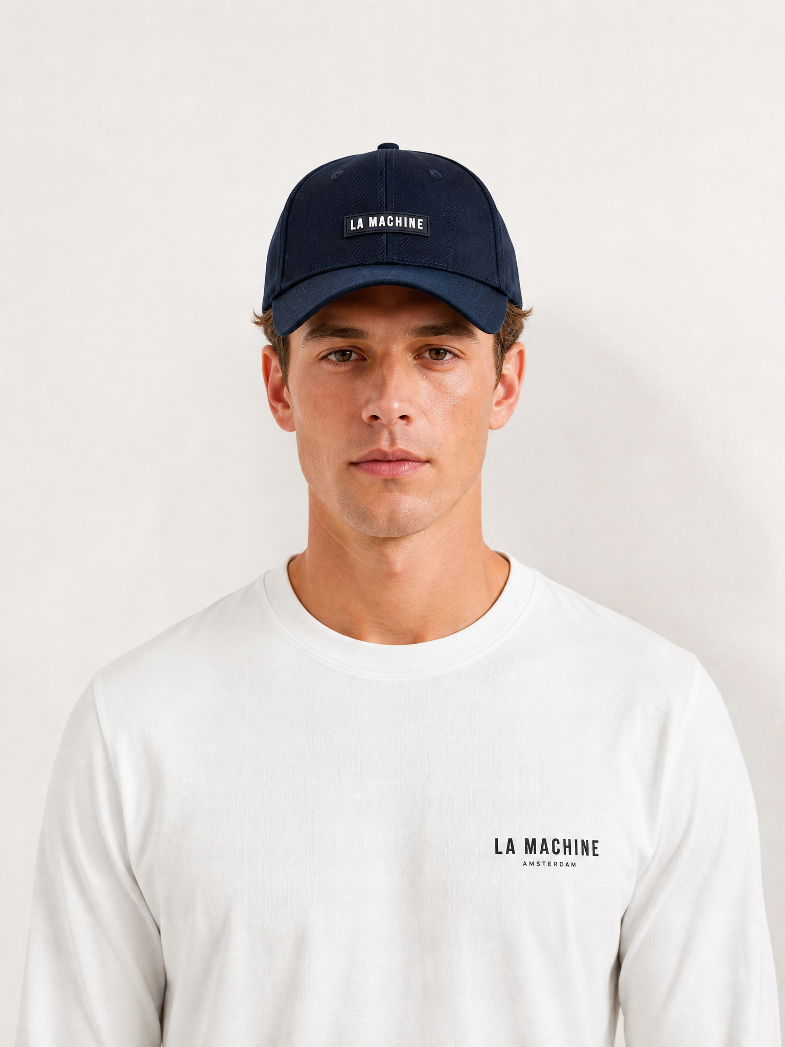 A model wearing the La Machine Logo - Casual Cap by La Machine Cycle Club.