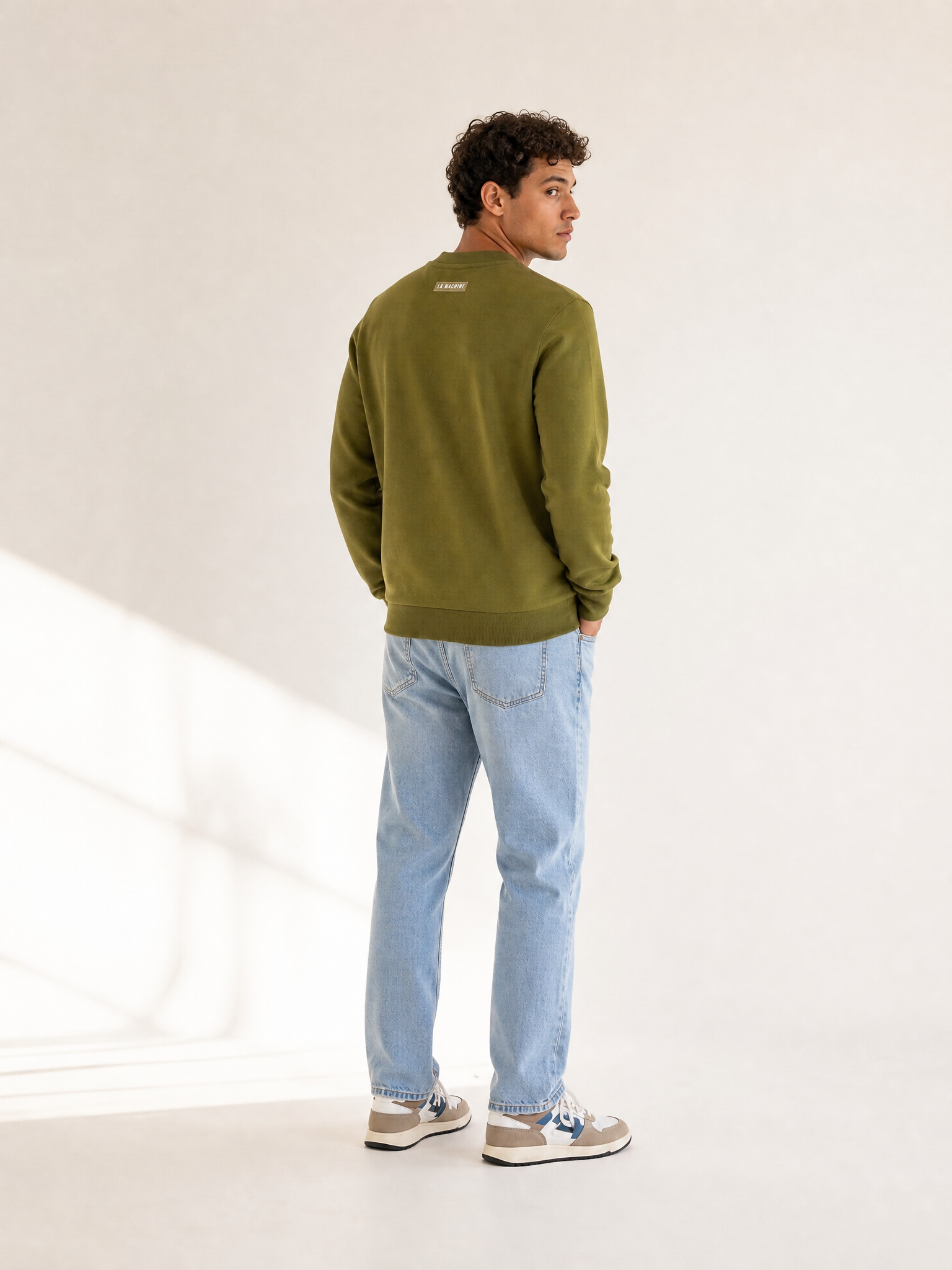 A model wearing the La Machine Club Line - Sweatshirt - Olive by La Machine Cycle Club.