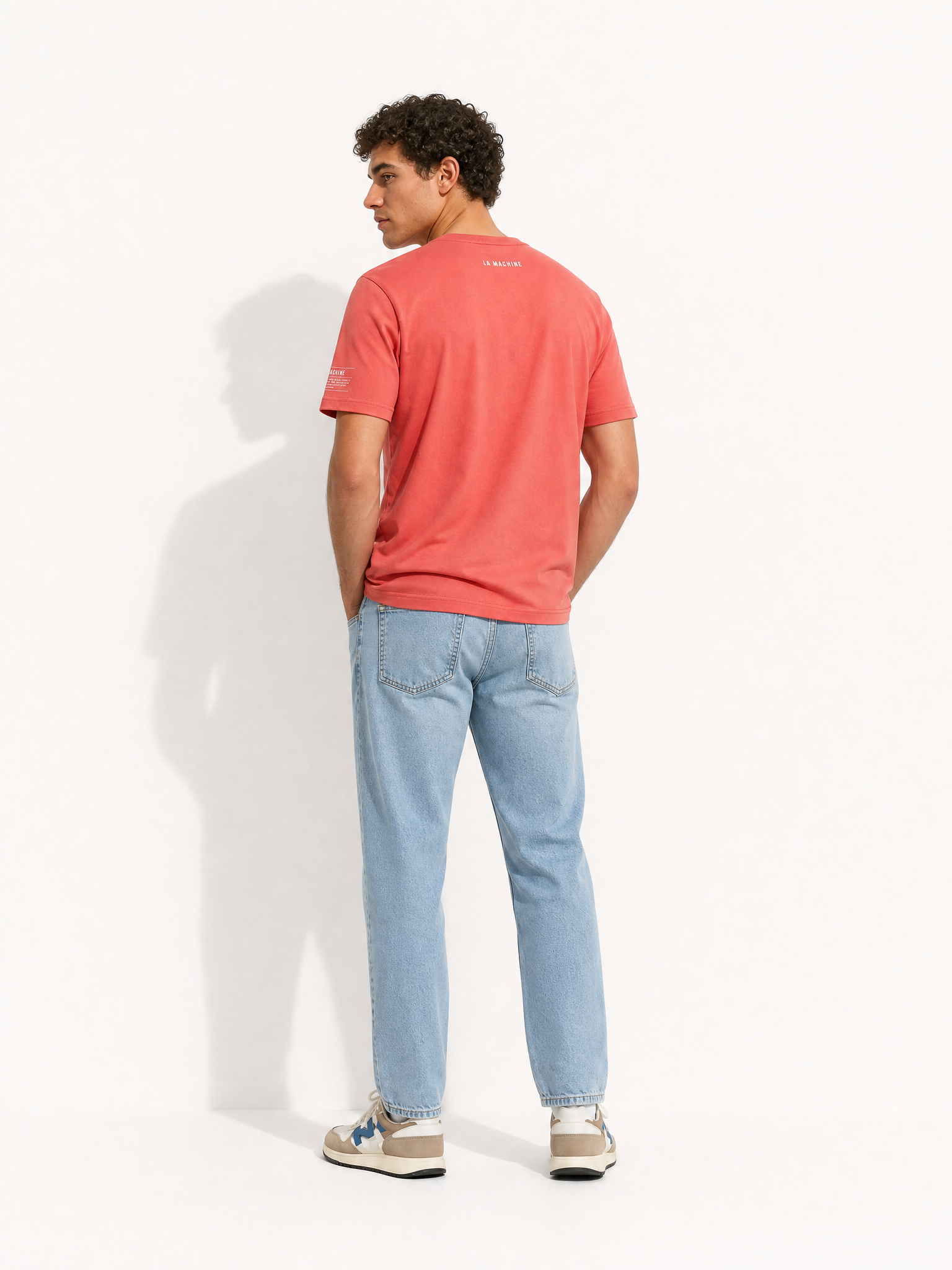 A model wearing the Pedaleur de Charme - T-shirt - Coral by La Machine Cycle Club.