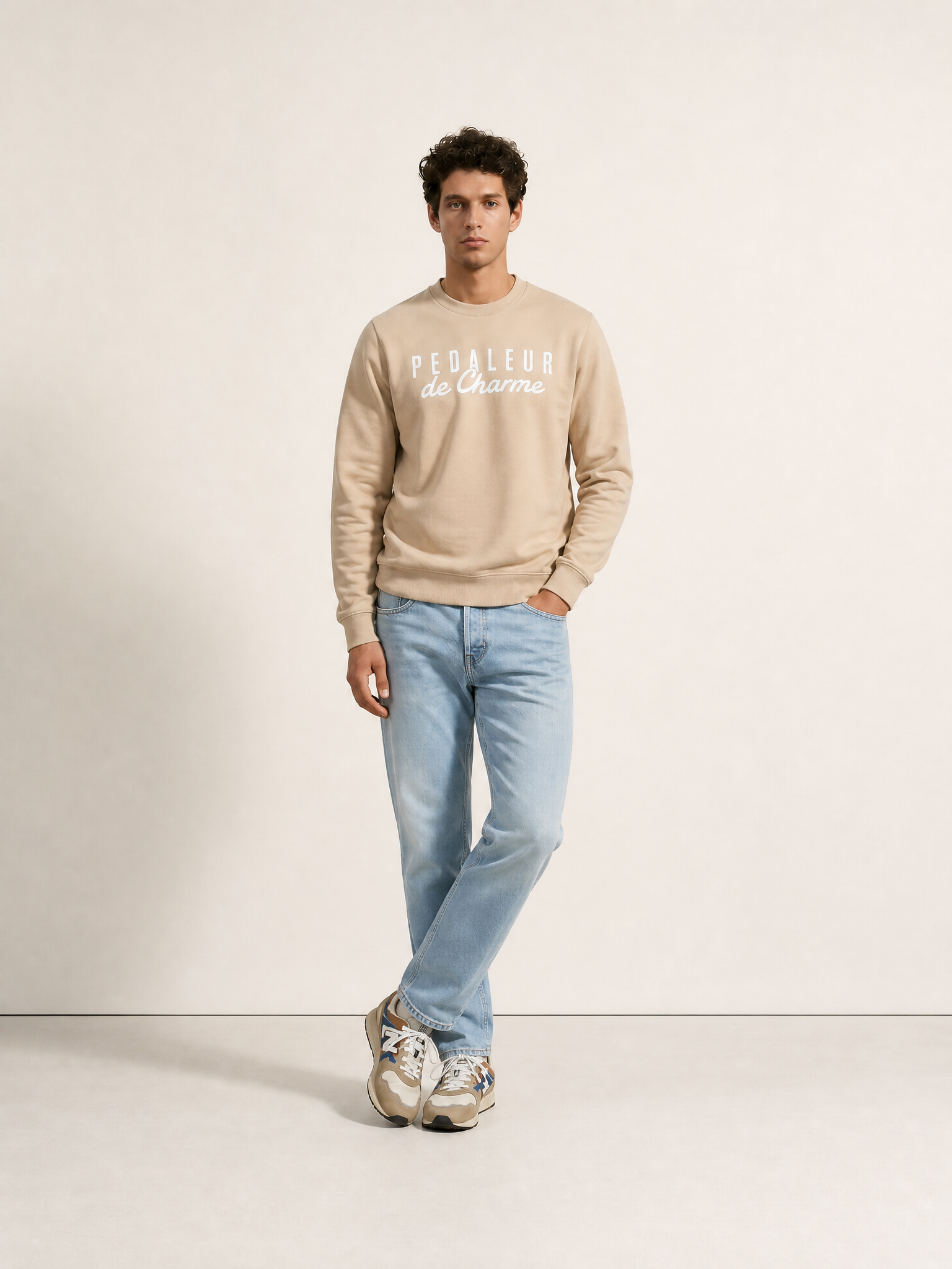 A model wearing the Pedaleur de Charme - Sweatshirt - Sand by La Machine Cycle Club.