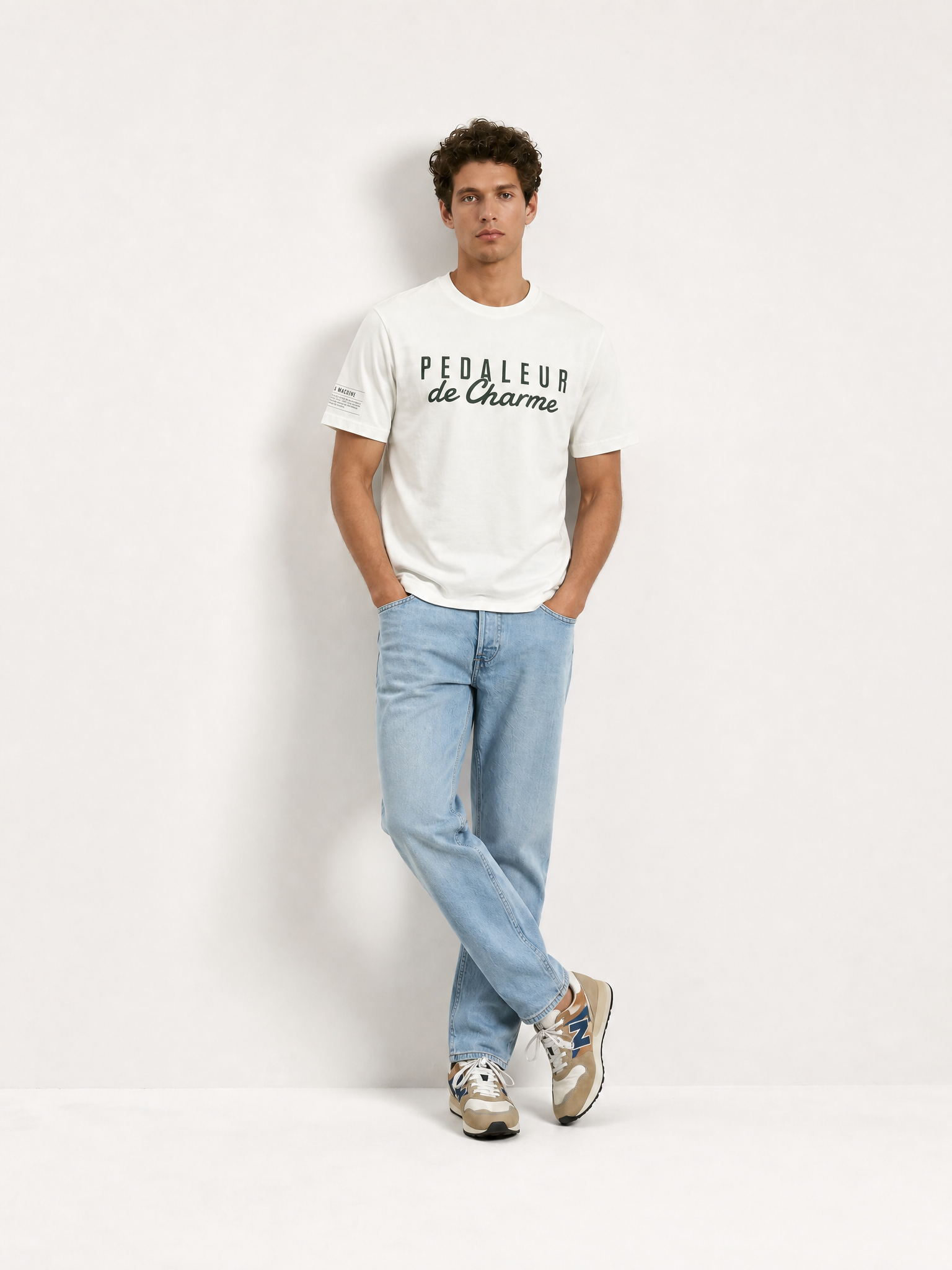 A model wearing the Pedaleur de Charme - T-shirt - Off White by La Machine Cycle Club.