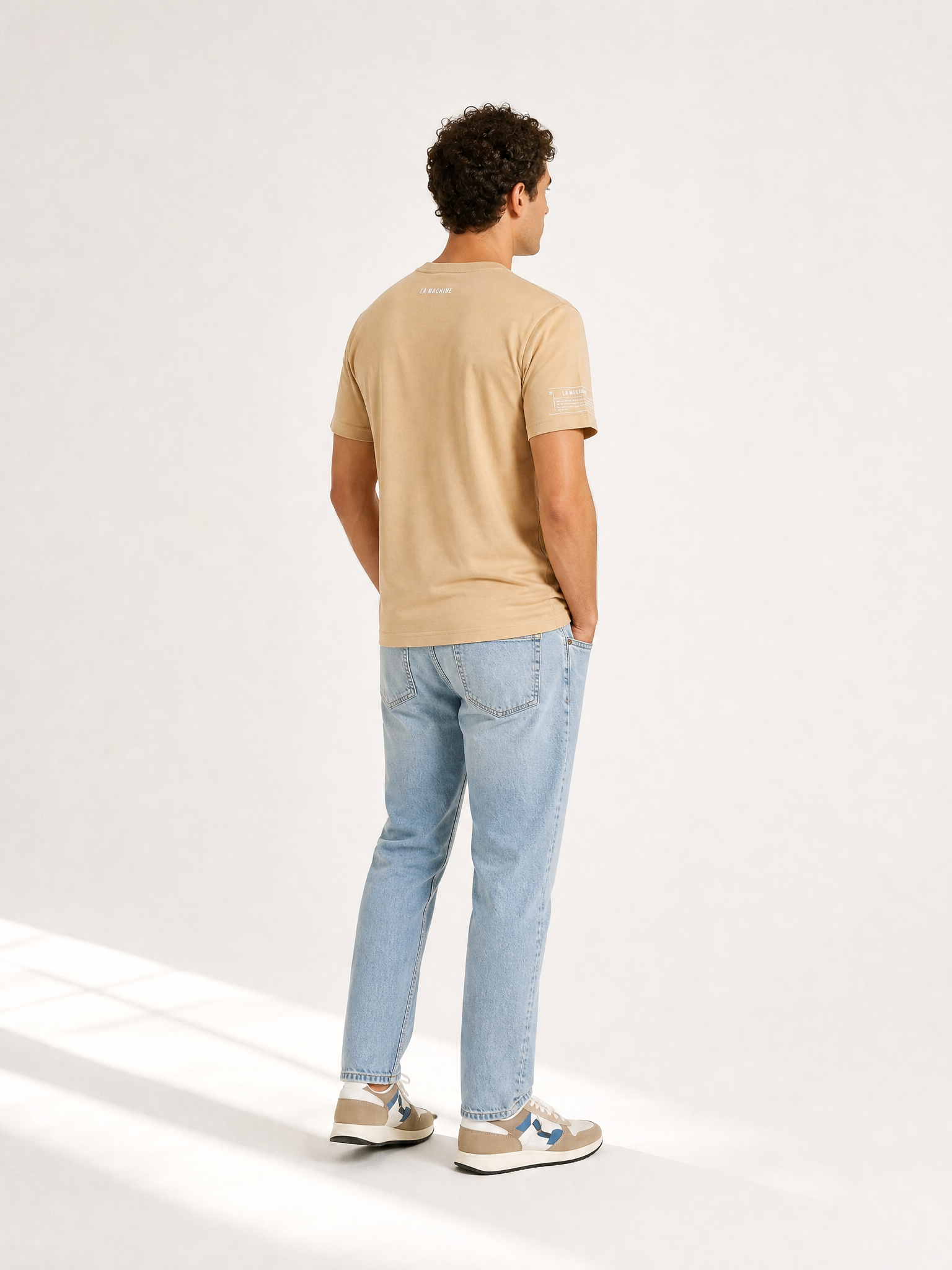 A model wearing the Pedaleur de Charme - T-shirt - Sand by La Machine Cycle Club.