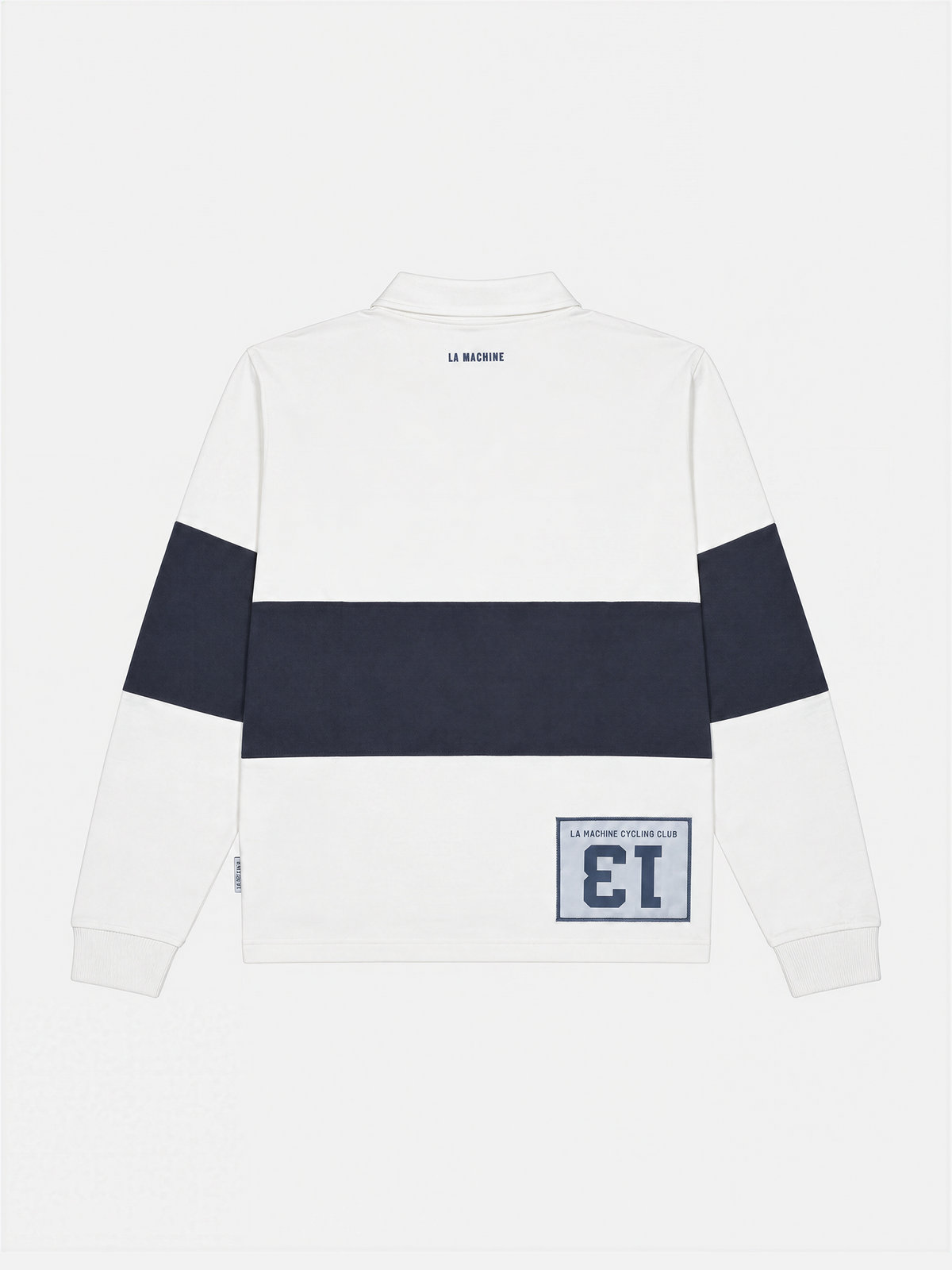 Close-up of the Number 13 Longsleeve Polo in dark navy blue and off white, shown on a model.